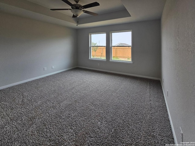 unfurnished room with carpet floors, ceiling fan, and a tray ceiling