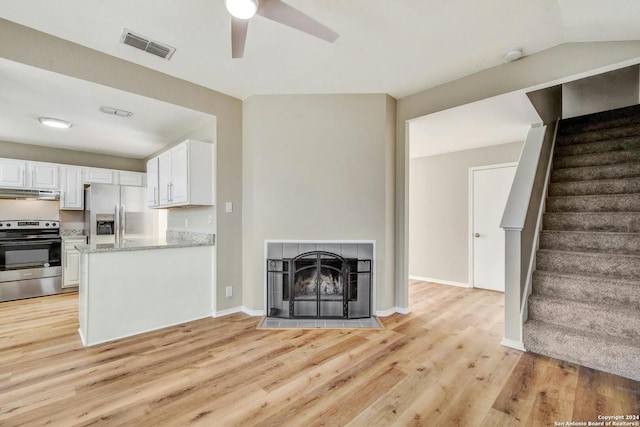 kitchen with light hardwood / wood-style floors, stainless steel appliances, light stone countertops, ceiling fan, and white cabinetry