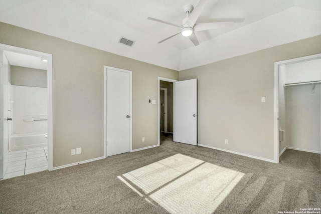 unfurnished bedroom with ceiling fan, ensuite bathroom, vaulted ceiling, and carpet floors