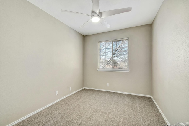 carpeted spare room featuring ceiling fan