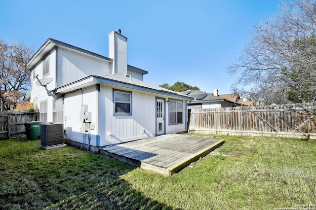 rear view of house featuring central air condition unit, a deck, and a yard