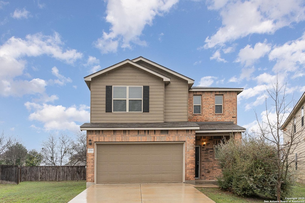 view of property featuring a front yard and a garage