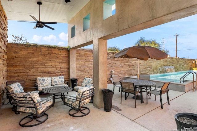 view of patio with ceiling fan, a fenced in pool, outdoor lounge area, and pool water feature