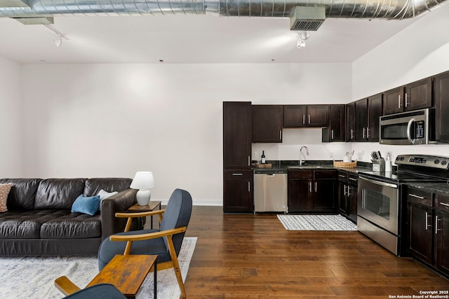 kitchen featuring sink, dark brown cabinetry, appliances with stainless steel finishes, and dark hardwood / wood-style flooring