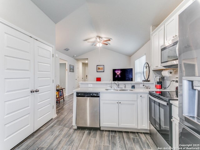 kitchen featuring stainless steel appliances, sink, white cabinetry, ceiling fan, and kitchen peninsula