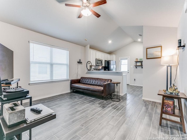 living room featuring lofted ceiling, ceiling fan, and light hardwood / wood-style floors