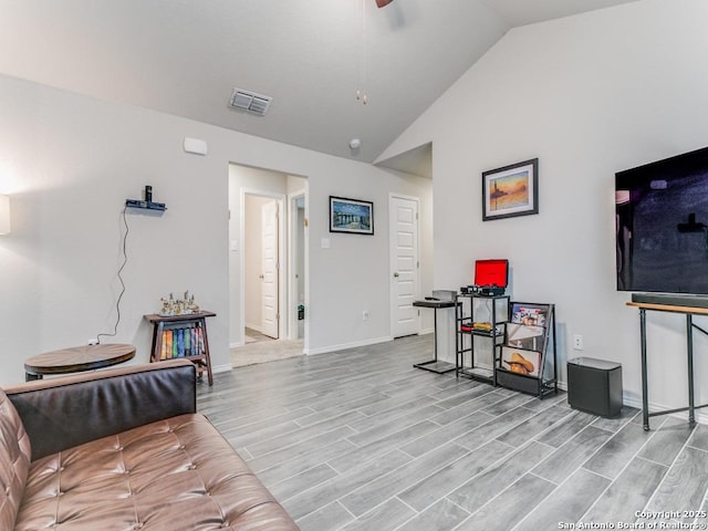 living room featuring light hardwood / wood-style floors, ceiling fan, and lofted ceiling