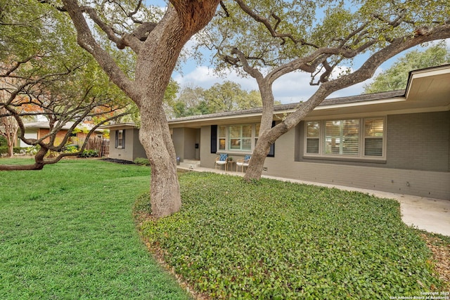 view of front of house featuring a patio area and a front lawn