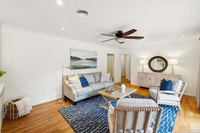 living room featuring ceiling fan, hardwood / wood-style floors, and ornamental molding