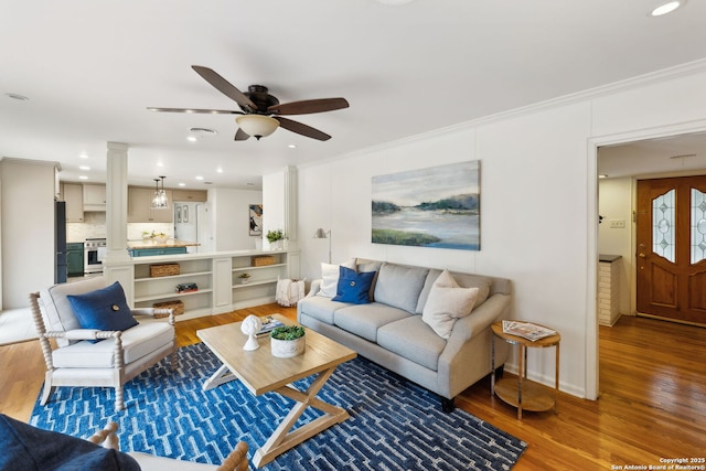 living room with ceiling fan, dark wood-type flooring, and ornamental molding