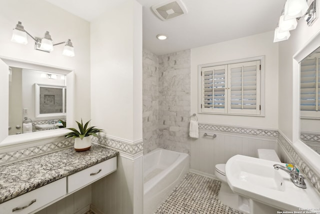 full bathroom with sink, toilet, tiled shower / bath, and tile patterned flooring