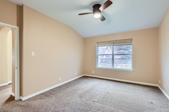 spare room featuring vaulted ceiling, carpet flooring, and ceiling fan