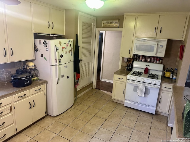 kitchen featuring white appliances, white cabinets, and light tile patterned floors