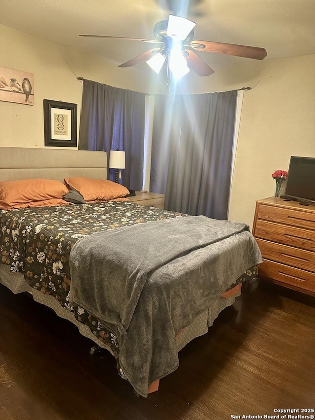 bedroom with ceiling fan and dark wood-type flooring