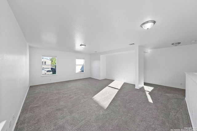 unfurnished living room featuring dark colored carpet