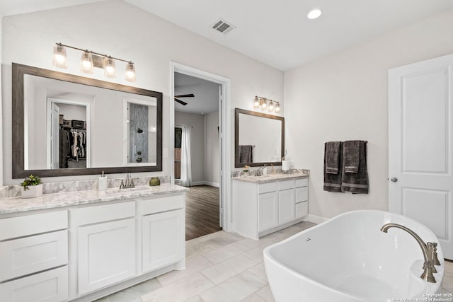 bathroom featuring ceiling fan, a tub, and vanity