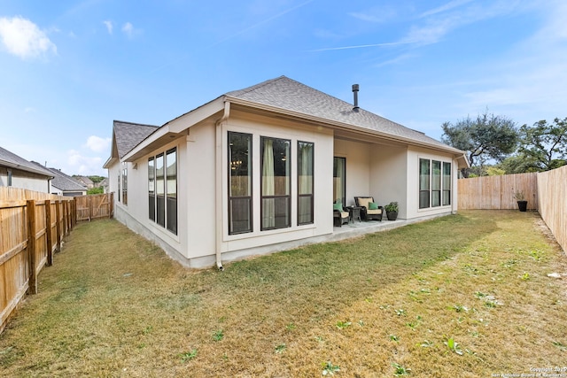 back of property with a yard and a patio