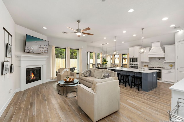 living room featuring ceiling fan and light hardwood / wood-style floors