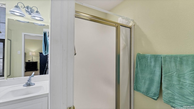 bathroom featuring sink and a shower with shower door