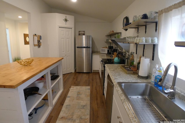 kitchen featuring butcher block countertops, stainless steel appliances, light wood-type flooring, white cabinets, and sink