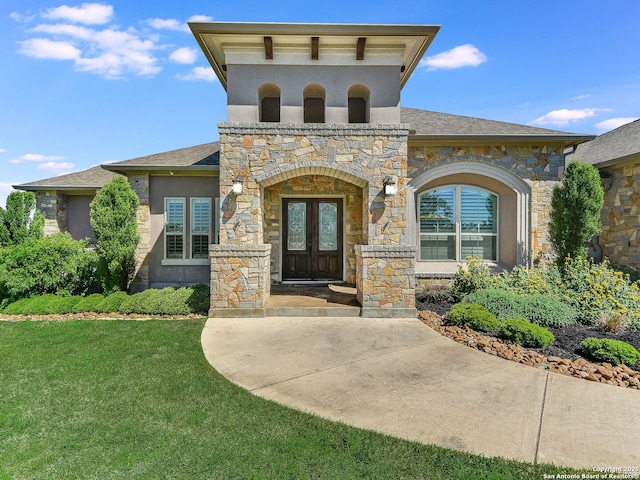 entrance to property with french doors and a lawn