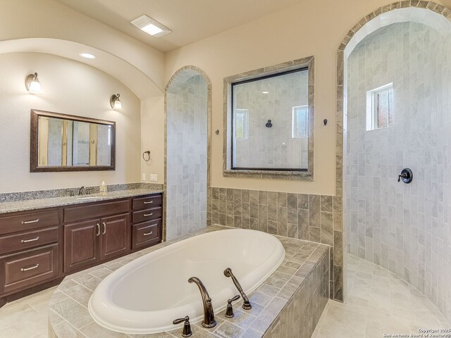 bathroom featuring independent shower and bath, tile patterned flooring, and vanity