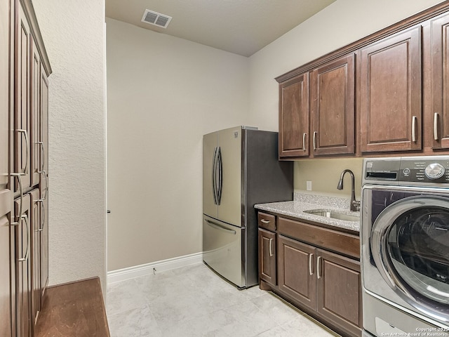 washroom featuring sink, washer / clothes dryer, and cabinets