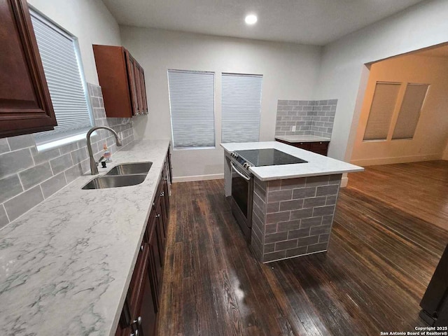 kitchen featuring dark wood-type flooring, decorative backsplash, a kitchen island, electric range, and sink