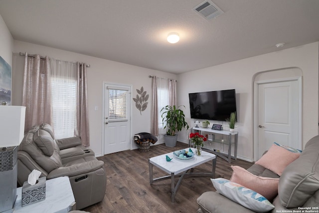 living room featuring a textured ceiling and dark wood-type flooring