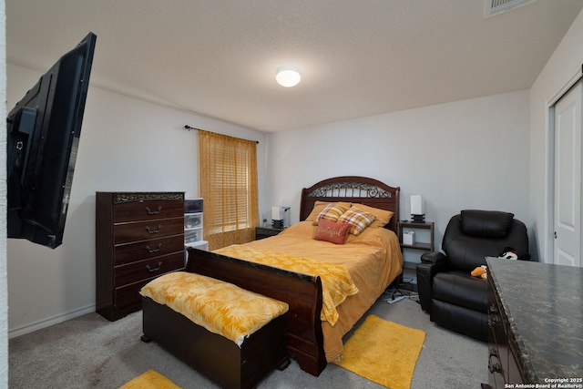 carpeted bedroom with a textured ceiling and a closet