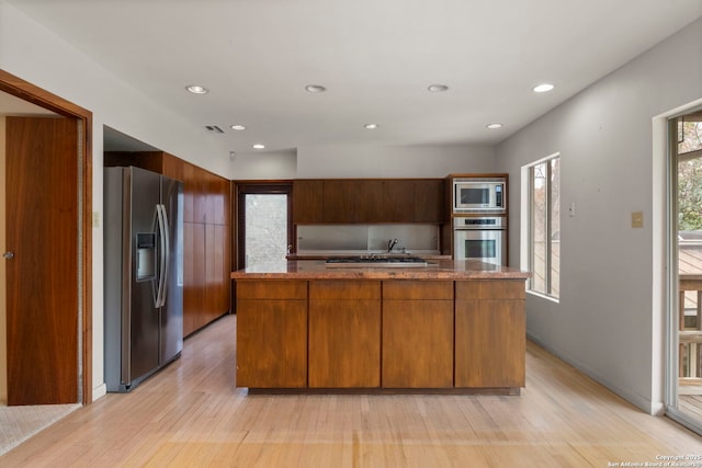 kitchen with a center island, light hardwood / wood-style flooring, and appliances with stainless steel finishes