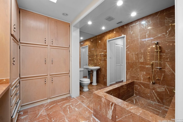 bathroom featuring tile walls, sink, a shower, and toilet