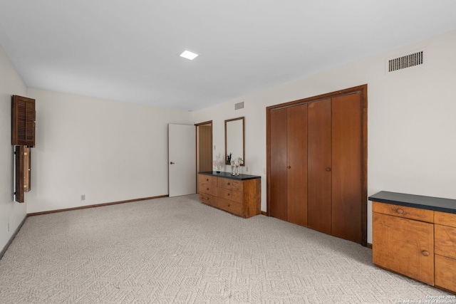 unfurnished bedroom with a closet and light carpet