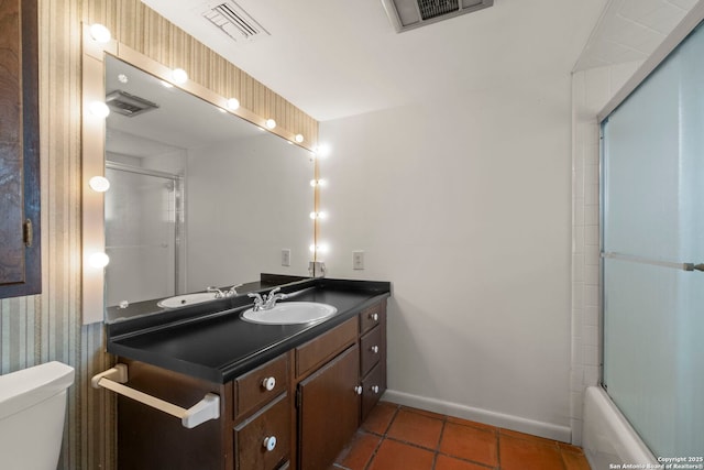 full bathroom featuring toilet, tile patterned flooring, vanity, and bath / shower combo with glass door