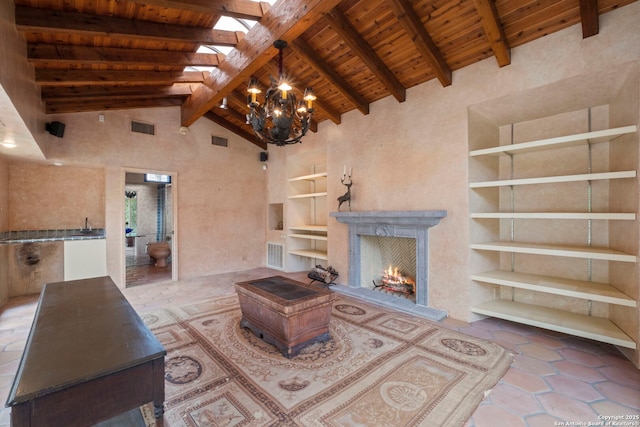 unfurnished living room with a notable chandelier, wood ceiling, built in shelves, high vaulted ceiling, and beam ceiling