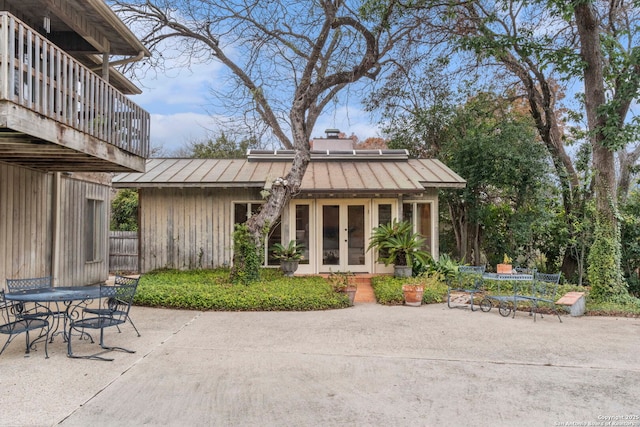 rear view of house featuring french doors, a balcony, and a patio