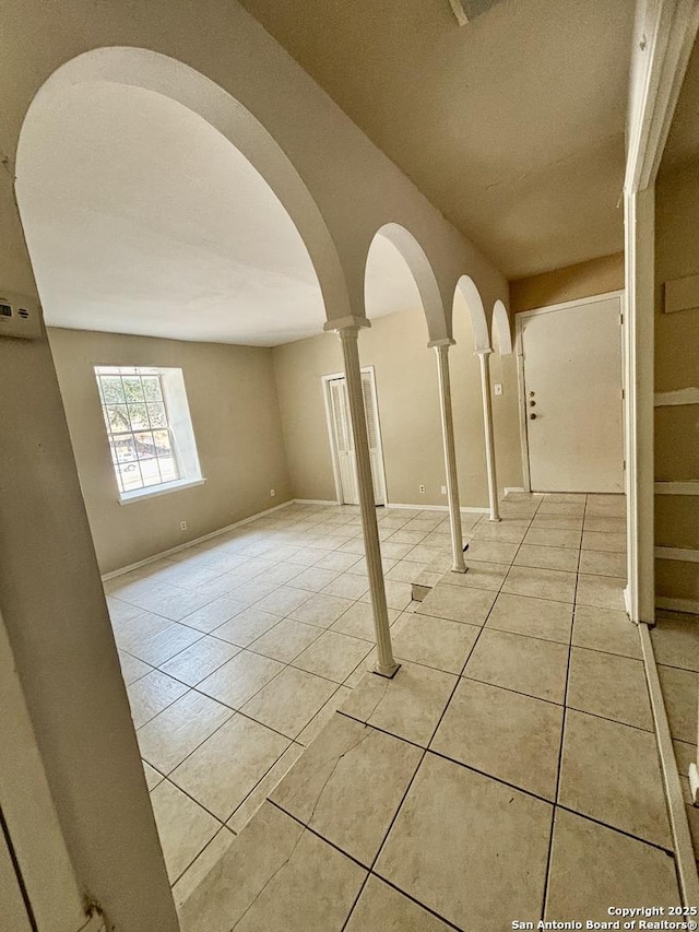 tiled empty room featuring ornate columns