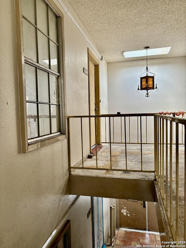 stairs featuring a textured ceiling and a skylight