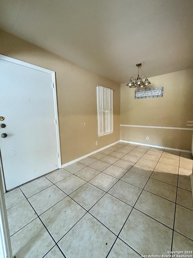 unfurnished dining area featuring light tile patterned floors and a chandelier