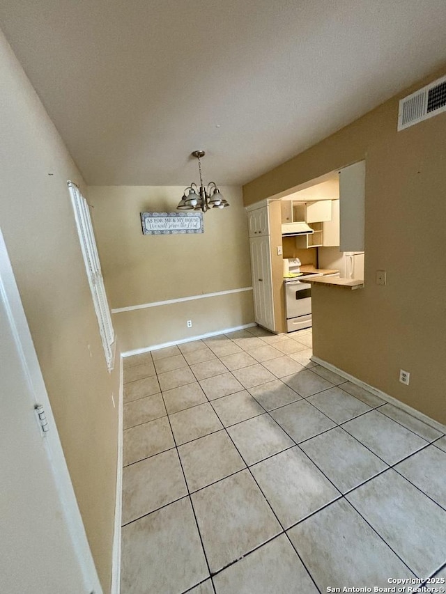 unfurnished dining area with light tile patterned flooring and an inviting chandelier