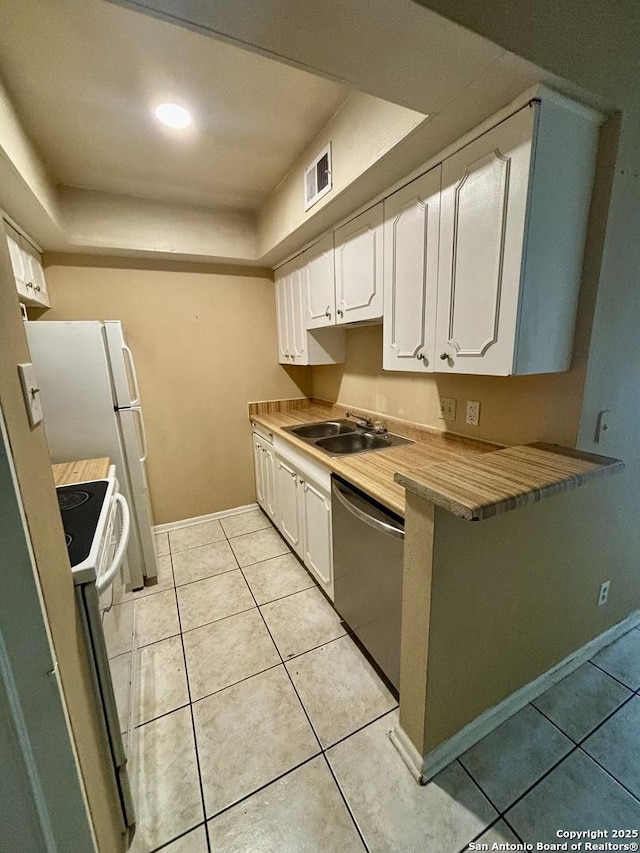 kitchen with sink, white cabinets, white electric stove, stainless steel dishwasher, and a tray ceiling