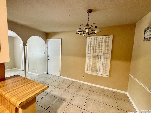 dining room featuring a textured ceiling, a chandelier, and light tile patterned floors