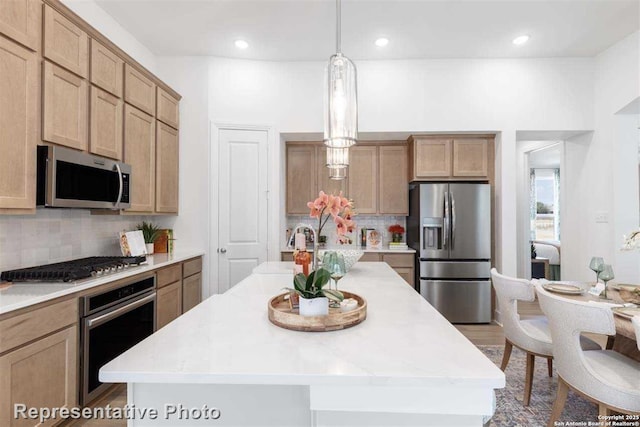 kitchen with stainless steel appliances, a kitchen island with sink, tasteful backsplash, and hanging light fixtures