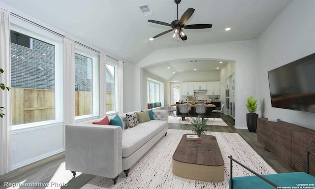 living room featuring ceiling fan, vaulted ceiling, and light wood-type flooring