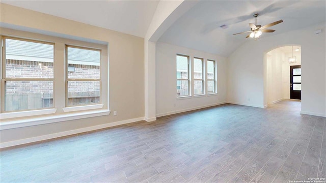 unfurnished living room with ceiling fan, vaulted ceiling, and light hardwood / wood-style floors