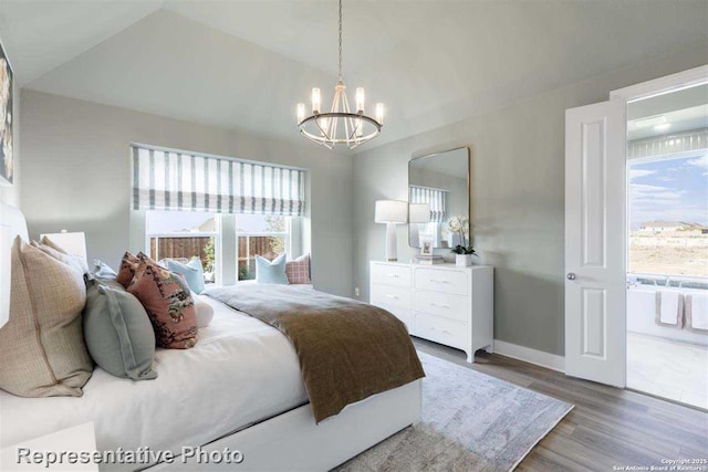 bedroom with vaulted ceiling, hardwood / wood-style flooring, and a notable chandelier