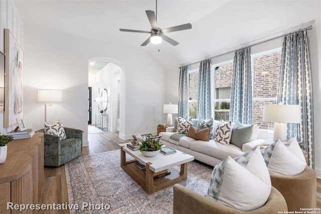 living room with ceiling fan, light wood-type flooring, and lofted ceiling