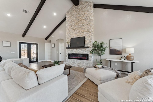 living room with a fireplace, high vaulted ceiling, and beamed ceiling