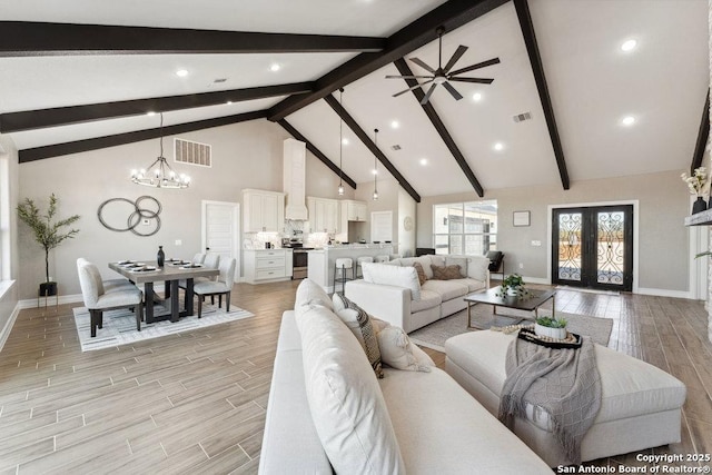 living room with ceiling fan with notable chandelier, high vaulted ceiling, french doors, and beam ceiling