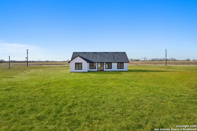 view of front of home featuring a rural view and a front lawn